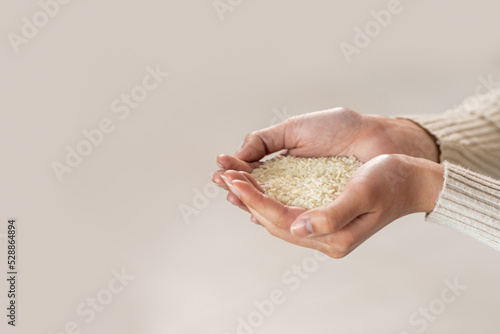 Unrecognizable woman hands with handful of rice  white background