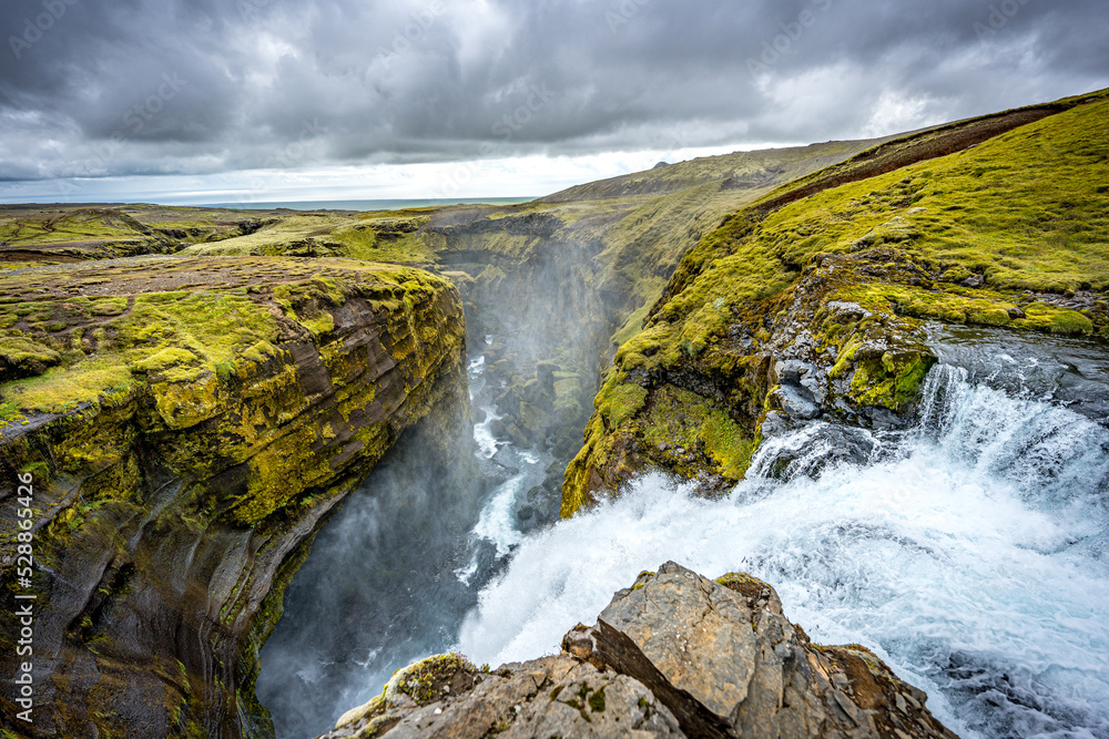 waterfall, river and country volcanic landscape with rocks, Iceland