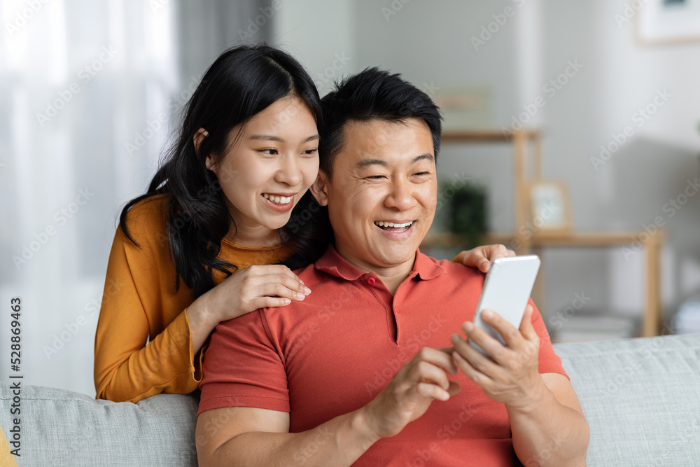 Cheerful chinese lovers having video chat with friends, copy space
