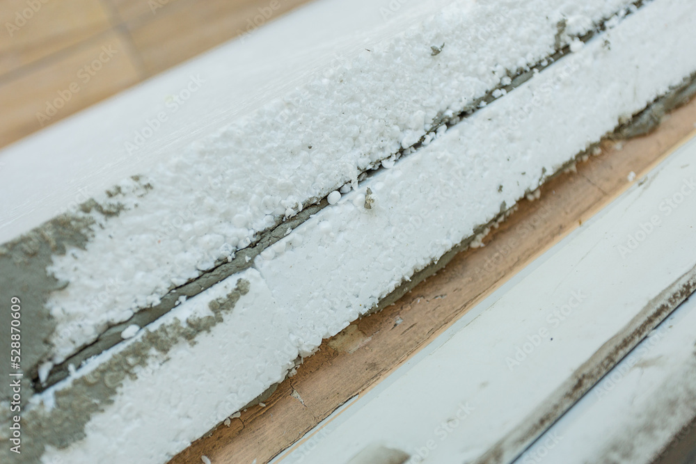 Modern repair and reconstruction of the house. Insulation of the house with polystyrene foam, plastering, applying plaster and painting facade walls using scaffolding when repairing the house. Modern repair and reconstruction of the house. Insulation of the house with polystyrene foam, plastering, applying plaster and painting facade walls using scaffolding when repairing the house.