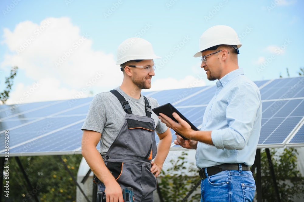near the solar panels, the employee shows the work plan to the boss. near the solar panels, the employee shows the work plan to the boss.