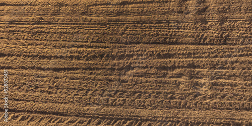 panorama of surface from above of gravel road with car tire tracks