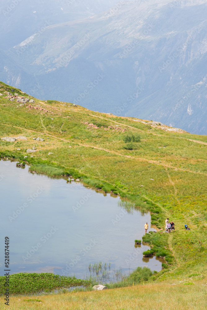 un lac de montagne dans les Alpes. Un groupe de randonneurs dans les Alpes. 