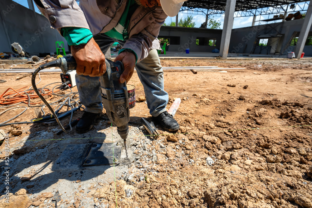 Asian construction workers use tools to drill masonry floors. Asian construction workers use tools to drill masonry floors.