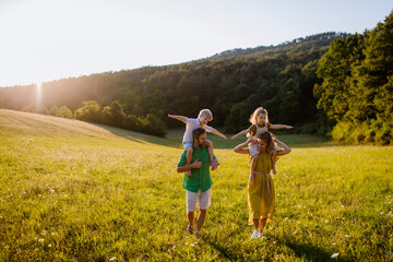 Happy young family spending time together outside in green nature.