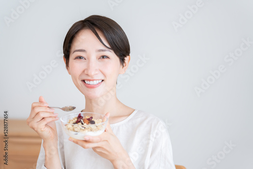 グラノーラを食べるミドル女性（朝食・食事・健康）