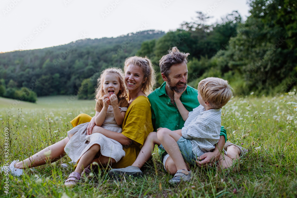 Fototapeta premium Happy young family spending time together outside in green nature.