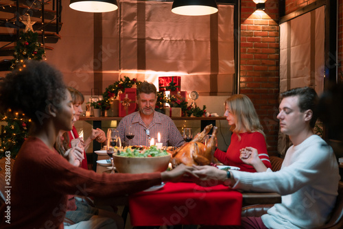 Family praying to the Lord before eating on Christmas day.