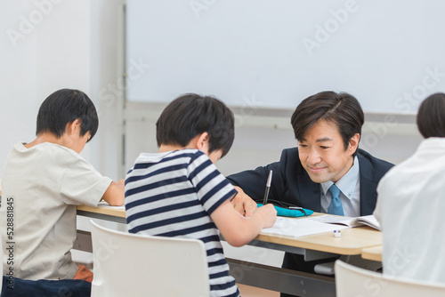 小学生に勉強を教える厳しい塾講師・先生（日本人男性） 