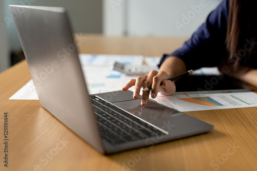 Close up woman using calculator and laptop, reading documents, young female checking finances, counting bills or taxes, online banking services