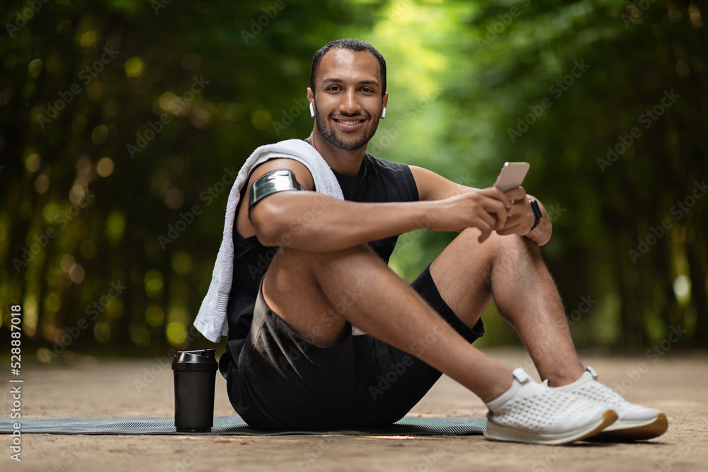 Fototapeta premium Cheerful african american guy jogger having break