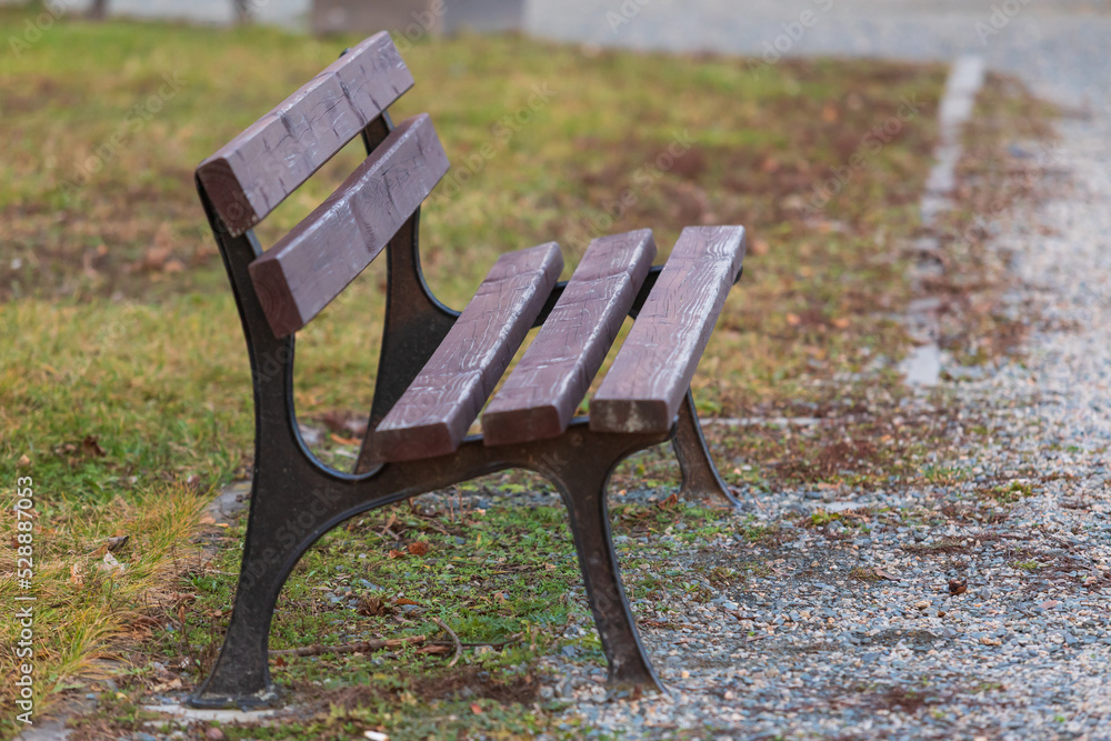 A wooden park bench on a gravel path. A wooden park bench on a gravel path.