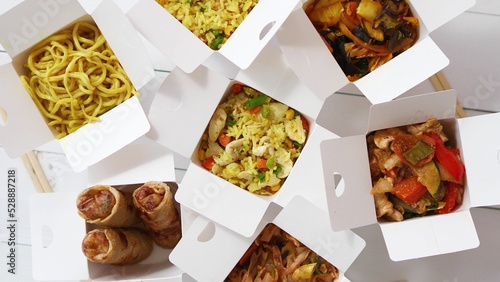 Take away food concept. Spring rolls, fried rice with chicken, curry and wok noodles photo