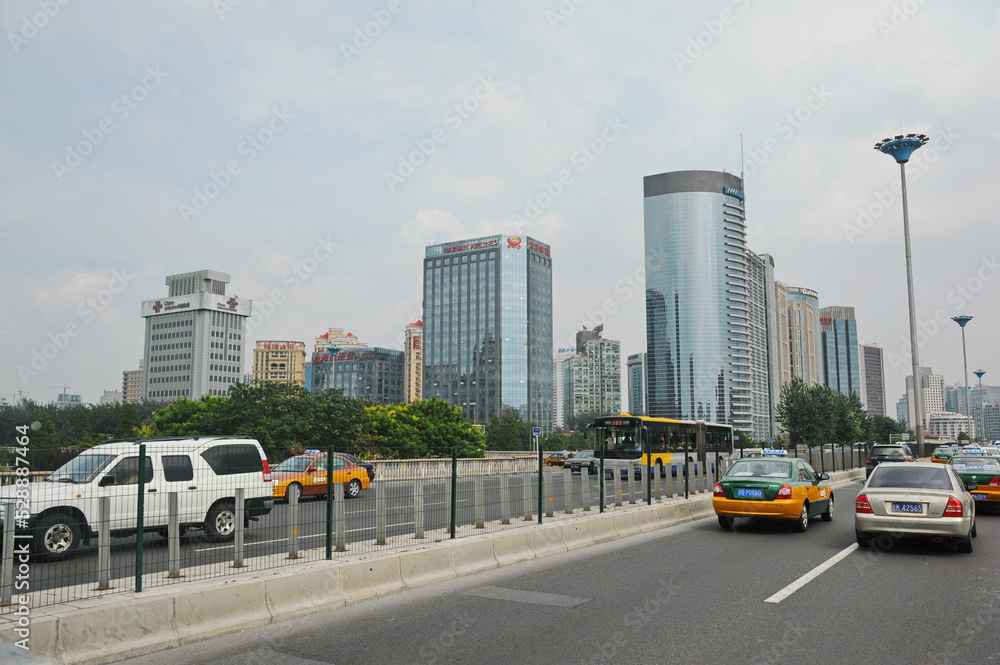 Naklejka premium Beijing, China - 08.05.2012 : Public and private transport travels along Central streets with dividing lanes