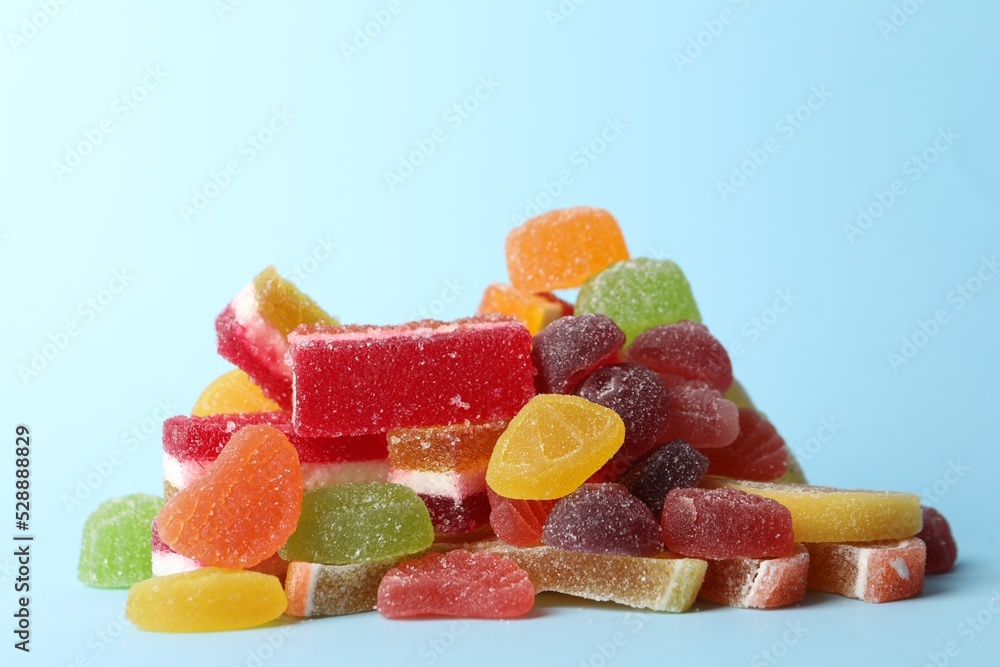 Pile of delicious bright jelly candies on light blue background Pile of delicious bright jelly candies on light blue background