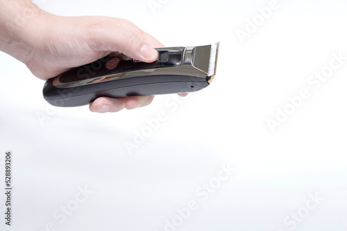 man's hand holding a hair clipper on white background