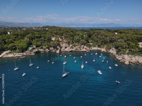 Aerial view of Cap d'Antibes and Billionaire's Bay. Beautiful rocky beach near coastal path on the Cap d'Antibes, Antibes, France. Drone view from above of Côte d’Azur near Juan-les-Pins and Cannes.