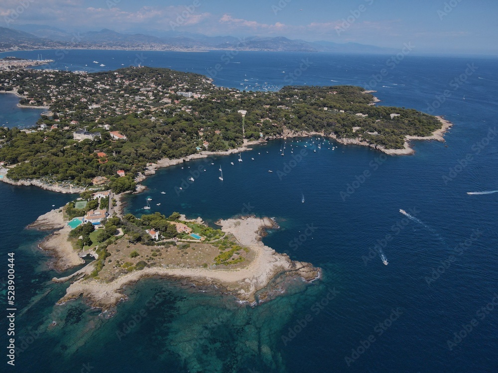 Aerial view of Cap d'Antibes and  Billionaire's Bay. Beautiful rocky beach near coastal path on the Cap d'Antibes, Antibes, France. Drone view from above of Côte d’Azur near Juan-les-Pins and Cannes.