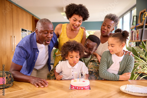 Multi-Generation Family With Military Father Celebrating Birthday With Cake Ay Home