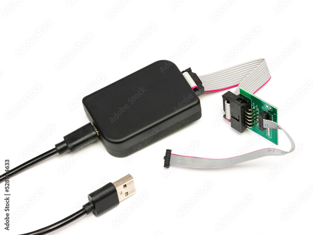 A modern programmer with a usb cable for chips and memory, with a connected flat cable and an adapter. Isolated on a white background with a light shadow. A modern programmer with a usb cable for chips and memory, with a connected flat cable and an adapter. Isolated on a white background with a light shadow.