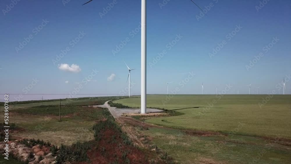 Video of windmills generating electricity and power next to pink salt lake. Drone video Video of windmills generating electricity and power next to pink salt lake. Drone video