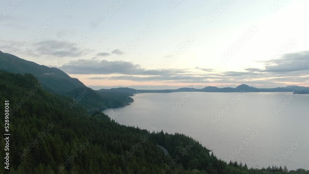 Lake with mountains and green trees. Sunset Sky Twilight. Canadian Nature Background. Aerial View from Above. Kennedy Lake in Vancouver Island near Tofino and Ucluelet, British Columbia, Canada. Lake with mountains and green trees. Sunset Sky Twilight. Canadian Nature Background. Aerial View from Above. Kennedy Lake in Vancouver Island near Tofino and Ucluelet, British Columbia, Canada.