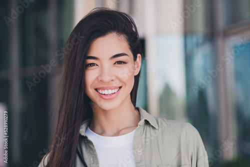 Photo of adorable positive girlfriend wear green outfit enjoying sunny weather smiling outdoors city residential complex