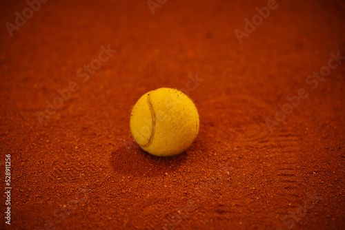 the ball for tennis lies on the red court, sports