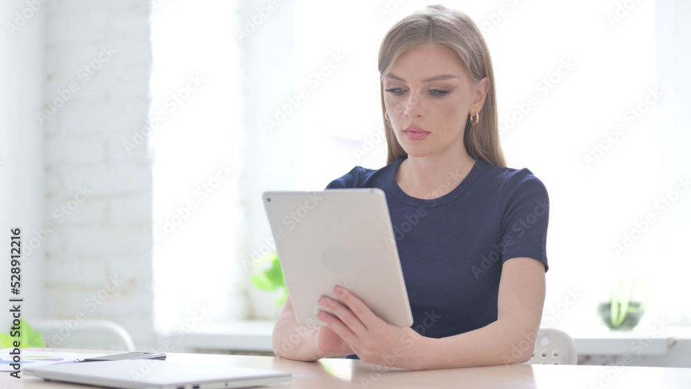 Woman using Tablet while Sitting in Office Woman using Tablet while Sitting in Office