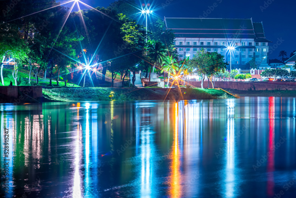 Beautiful lights water reflection full of banks of the Nan River at night on the bridge (Naresuan Bridge)at night in the park in Phitsanulok City,Thailand.