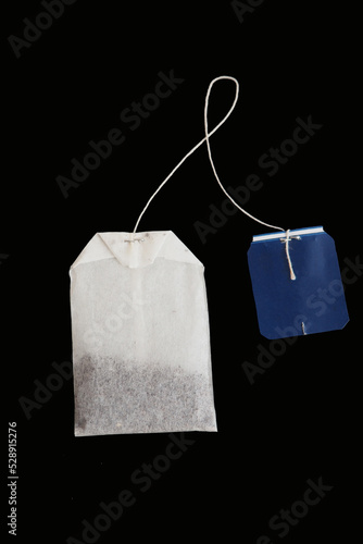 Rectangular tea bag with blue label isolated on black. Mockup, detail for creating marketing compositions in the theme of tea party, food products