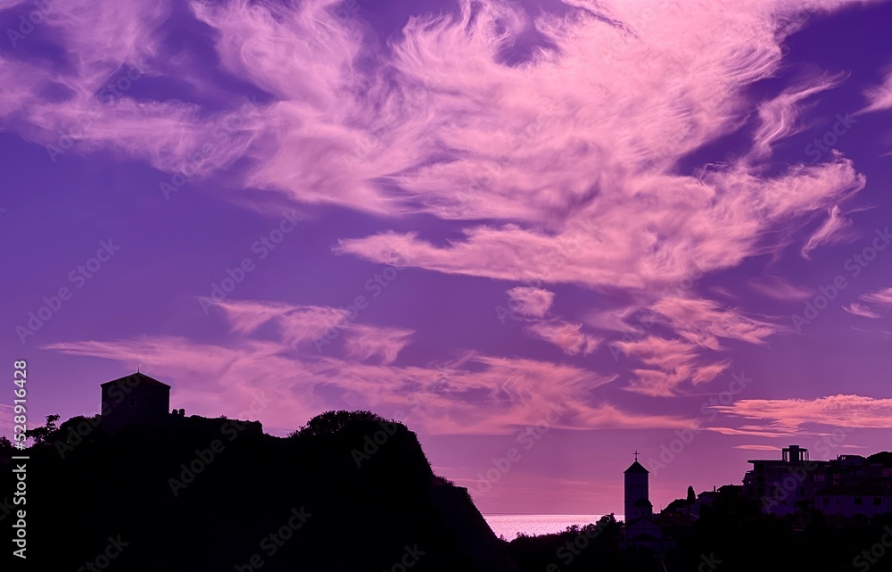 Obraz premium Dark silhouette old town against impressive sunset sky clouds.