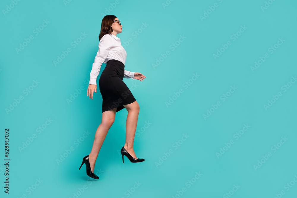 Full size profile portrait of successful pretty girl walk climb empty space stairs isolated on cyan color background Full size profile portrait of successful pretty girl walk climb empty space stairs isolated on cyan color background