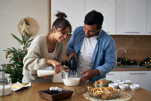 Multi ethnicity couple making a cake together in Christmas time