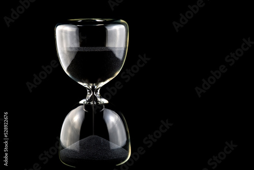Black Sand Hourglass Isolated Against a Black Background