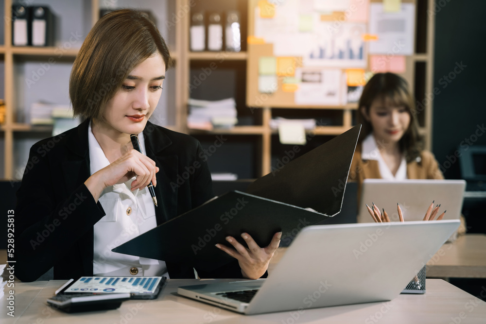 Business woman sitting on desk using laptop. Portrait of busy secretary typing in working environment. Happy young businesswoman in casual working on computer in office. Business woman sitting on desk using laptop. Portrait of busy secretary typing in working environment. Happy young businesswoman in casual working on computer in office.