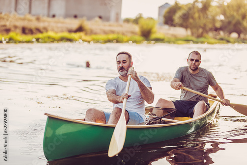 Two adults rowing Kayak On Lake Together.
