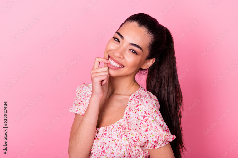 Photo of gorgeous thai person beaming smile teeth bite finger nail isolated on pink color background Photo of gorgeous thai person beaming smile teeth bite finger nail isolated on pink color background