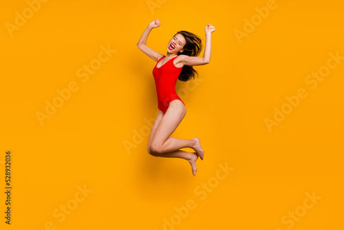 Full body photo of delighted excited person jump raise fists celebrate success isolated on yellow color background