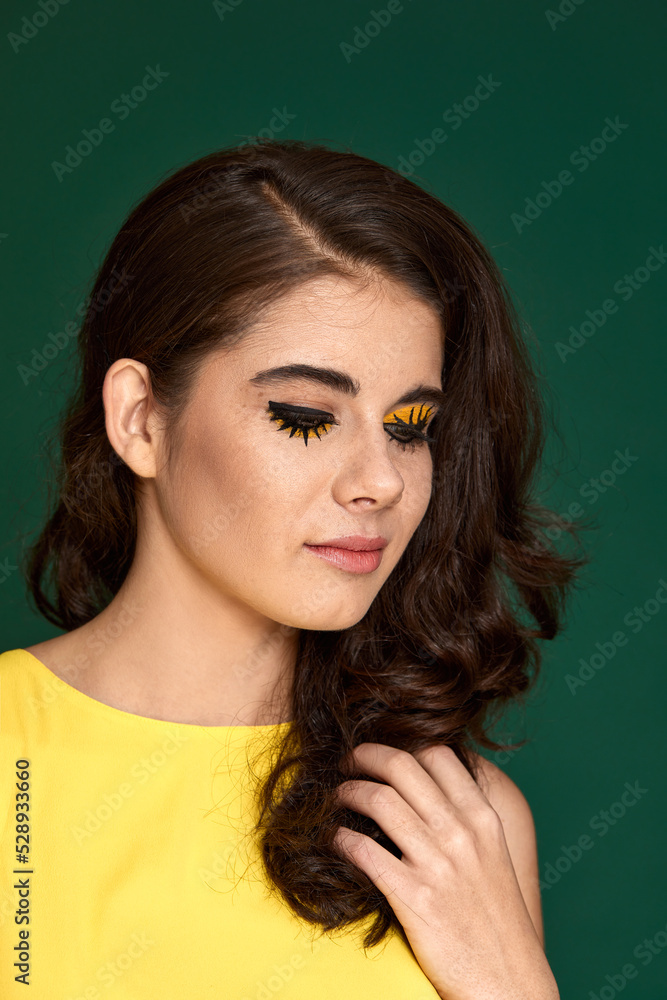 young curly woman with creative make-up in yellow dress young curly woman with creative make-up in yellow dress