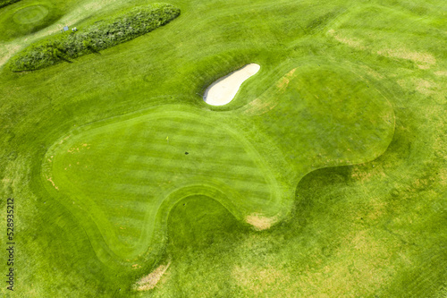 Aerial view of bunkers sand in golf court with putting green grass.