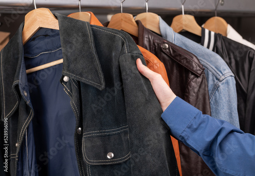 Person choosing vintage jacket in a used goods store
