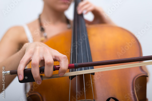 Canvas Print Young woman playing cello on the concert at night