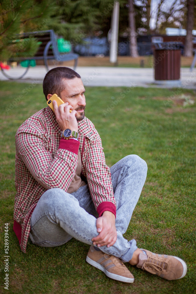 Man using mobile smart phone. Handsome man in park Man using mobile smart phone. Handsome man in park