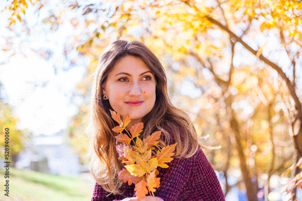 Beautiful woman in burgundy sweater on a background of autumn tree. Beautiful woman in burgundy sweater on a background of autumn tree.
