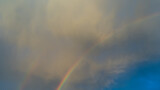 Rainbow in blue sky with white cloud after rain