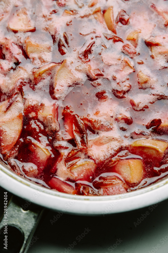 Plum and apple jam. Cooking cooking jam in a frying pan. Homemade jam with sugar syrup. The process of cooking, boiling berries for canning.Close-up top view Plum and apple jam. Cooking cooking jam in a frying pan. Homemade jam with sugar syrup. The process of cooking, boiling berries for canning.Close-up top view