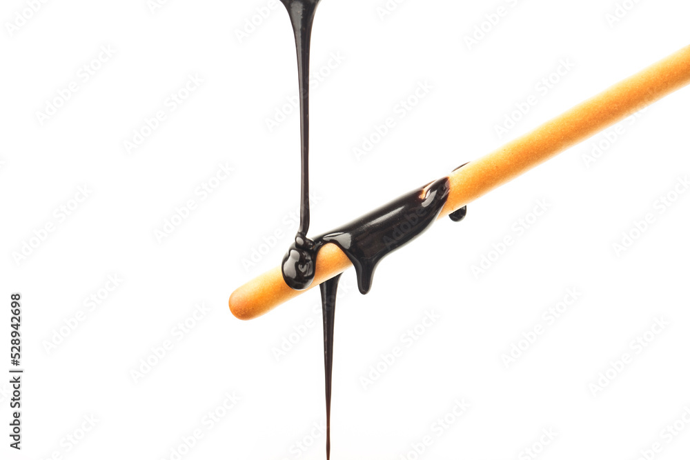 The chocolate sauce flows over the biscuit stick The chocolate sauce flows over the biscuit stick