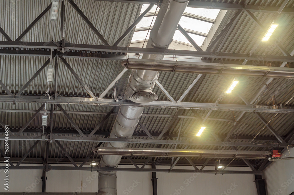 The ceiling of a large factory building with artificial lighting. Industrial background. The ceiling of a large factory building with artificial lighting. Industrial background.