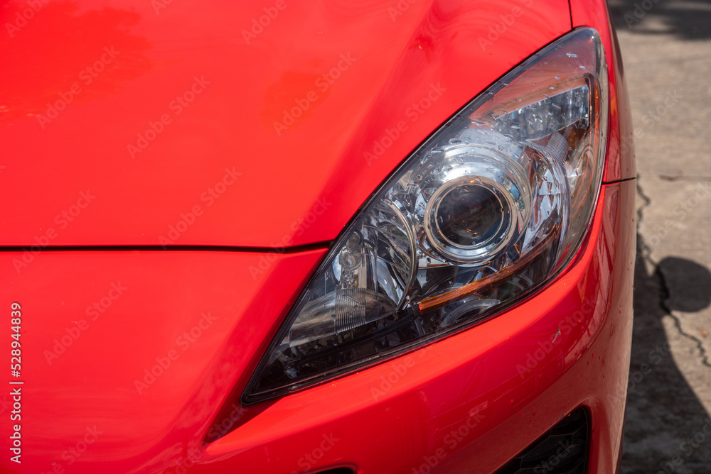 headlight of modern prestigious car closeup red car